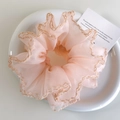 Detail of light pink organza scrunchie with champagne wavy embroidered edges on a white plate - Lotus Root Pink (26548C)