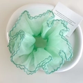 Détail du chouchou en organza vert clair avec bords à volants vert foncé sur assiette - Vert Menthe (26548F)