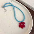 Detalle de collar de cordón trenzado azul con colgante de flor de acrílico rojo - Flor Roja (26566C)