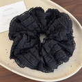 Detail van zwarte gelaagde kanten scrunchie met holle texturen op een keramisch bord - Zwart Stijl (26577B)