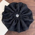 Detalle de un elegante coletero negro en tejido jacquard con textura suave y volantes - Negro