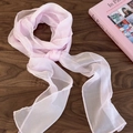 Close-up of soft pink chiffon scarf with fine stitching on a dark wood background - Pink