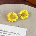 Macro di orecchini a margherita gialla con petali multistrato su piatto in ceramica - Fiore Giallo