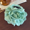 Close-up of a light green lace rose hair claw clip with floral embroidery on wood - Green