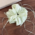 Détail de la texture d'un chouchou en organza vert menthe avec longs rubans en satin - Vert
