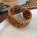 Detailed view of handmade woven rattan bangle on a ceramic tray with natural rustic aesthetic - Coffee - Open