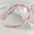 Gedetailleerde weergave van de lichtroze geribbelde hoofdband met gouden metalen logo - Roze Stijl (26678A)