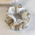 Dettaglio ravvicinato di elastico scrunchie a scacchi blu e arancio con pizzo bianco fine - Scrunchie a Quadretti Blu Bordo Spesso
