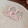 Macro detail of pink enamel heart hoop earrings resting on a beige ceramic plate - Pink Heart
