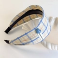 Close-up of plaid headband with blue heart charm and handmade tag on a shell tray - Blue Plaid Headband