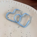 Macro detail of sky blue enamel heart hoop earrings on minimalist ceramic tray - Blue Heart