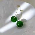 Detail of glittery green cherry earrings on a white ceramic plate with golden hooks - Green Style (26665E)