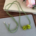 Détail du pendentif camélia givré sarcelle sur cordon en daim gris-vert style forêt - Fleur Verte Mate (26726F)