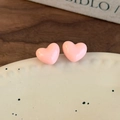 Gros plan sur des boucles d'oreilles rose en forme de cœur sur une assiette - Rose