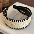 Detail van een bohemian strooien hoofdband met zwarte stiksels op een kunstboek - Beige met zwarte rand