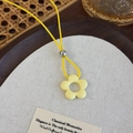 Primer plano del colgante de flor amarilla con cordón de cera y cuenta de metal pulido - Flor Amarilla