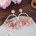 Close-up of pink fabric floral petals and metallic ring hoop on bohemian earrings - Pink