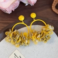 Detail of yellow fabric floral hoop earrings with sheer petals on a rustic background - Yellow