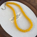 Vista dettagliata della collana di perline di vetro giallo su lino con chiusura - Giallo