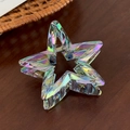 Detailed close-up of iridescent star hair claw showing acrylic texture and rainbow coating - Colorful Gray