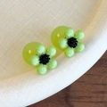 Dettaglio di orecchini a fiore in resina verde con chiusura a sfera verde traslucida - Fiore Verde