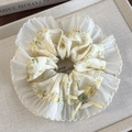 Detailaufnahme von Blumen-Haargummi mit Spitze und Schleife auf einem Leinentablett - Gelb Blumenmuster Runde Ausführung
