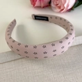 Dettaglio del cerchietto rosa floreale in tessuto imbottito con etichetta fatta a mano - Rosa