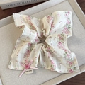 Detail eines Blumen-Haargummis mit rosa Schleife, Knopf und Hand Made Stofflabel - Rosa Blumenmuster Eckige Ausführung