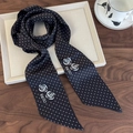 Detail of silk scarf with black white polka dots and white rose pattern on wooden table - Black With White Polka Dots