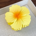 Vue détaillée de la pince à cheveux fleur jaune mat dégradé avec dents emboîtables sur plateau - Fleur Jaune