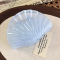 Close-up of a light blue pearlescent shell hair claw clip on a rustic linen background - Blue Shell (26822C)