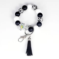 Silicone beaded keychain bracelet with cow print cross and black tassel charm - Cow Print White / White