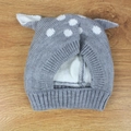 Detailed close-up of grey knitted deer hat with white polka dots and cute 3D ears - Gray