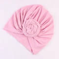 Detail eines rosa Turban-Hutes mit Falten-Design und weicher Stoffblumen-Verzierung - Rosa