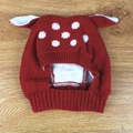 Detailed close-up of a red and white polka dot knit hat with cute 3D ears on wood background - Red