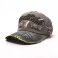 Detailed view of Black Rebel embroidery and distressed brim on washed baseball cap - One Size / Army Green Brim
