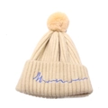 Détail d'un bonnet en maille côtelée blanc cassé avec pompon jaune et broderie bleue - Taille unique / Beige