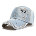 Détail d'une casquette en jean bleu clair avec motif de cygne en strass et rivets argentés - Taille unique / Cygne Bleu Clair