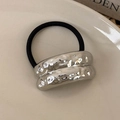 Close-up of silver textured metal charm with hammered finish on black elastic hair tie - Silver Double Pleat (25763F)