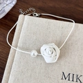 Close-up of a white leather rose and pearl on a minimalist snake chain choker - White Flower