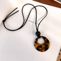 Detailed view of tortoiseshell resin ring pendant on black suede necklace cord - Dark Tortoiseshell