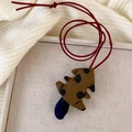 Detail eines handgefertigten Stoffanhängers im Waldstil mit Punkten auf Strickhintergrund - Große Baumform / Braun Punktiert