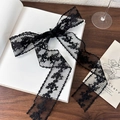 Dettaglio del nastro in pizzo nero con ricami floreali su un libro d'epoca - 1.5m / Vite Nera