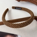 Detail of dark brown knitted headband with handmade label and twill texture - Brown