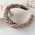 Detail eines mehrfarbig gestrickten Stirnbandes mit Hand-made-Etikett und Wolltextur - Mehrfarbiger Regenbogen (Hauptstil)