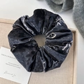 Dettaglio macro di elastico per capelli in velluto nero con fiocchi e pois bianchi - Elastico Tondo