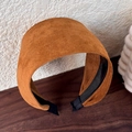Nahaufnahme eines breiten Stirnbands aus karamellfarbenem Wildlederimitat mit Struktur - Kaffeebraun