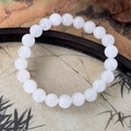 Detailaufnahme eines weißen Steinperlenarmbands auf einem traditionellen Tablett - Altweiß