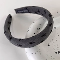Primer plano de diadema de punto gris con lazos negros y etiqueta de producto artesanal - Estilo de Lazo Gris