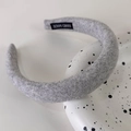 Detalle de diadema acolchada gris con etiqueta 'HAND MADE' en la tela interior - Estilo Engrosado de Lana Gris Oscuro
